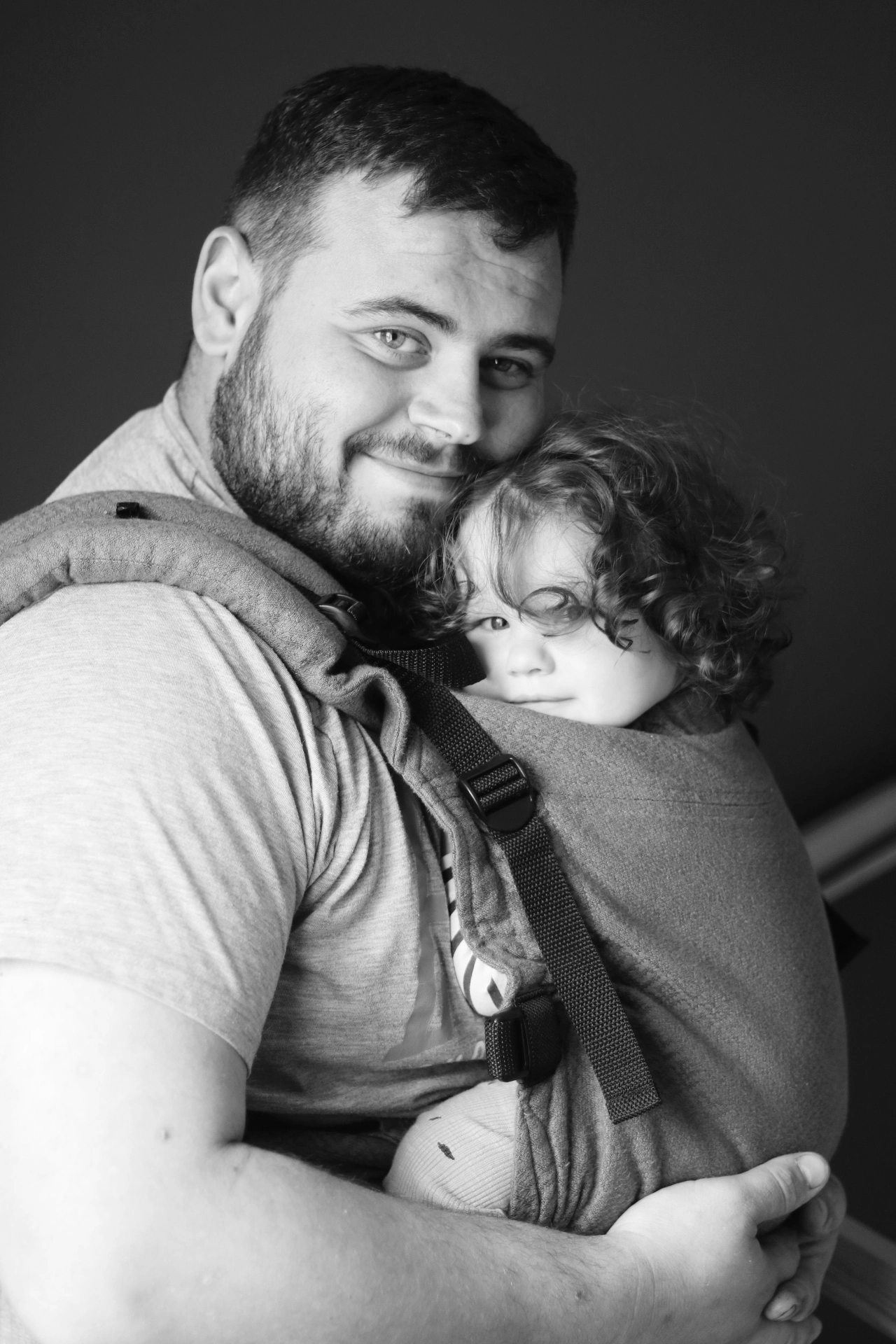 Un papa porte son bébé en écharpe